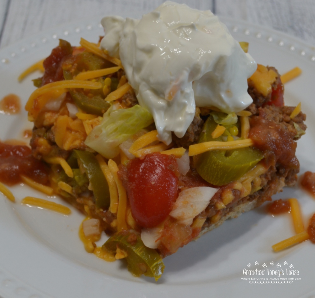 Taco Pizza Supreme is a mexican style pizza loaded with ground beef,sesoings,refried beans and cheese mixture.Taco toppings, sour cream and salsa round it off. 