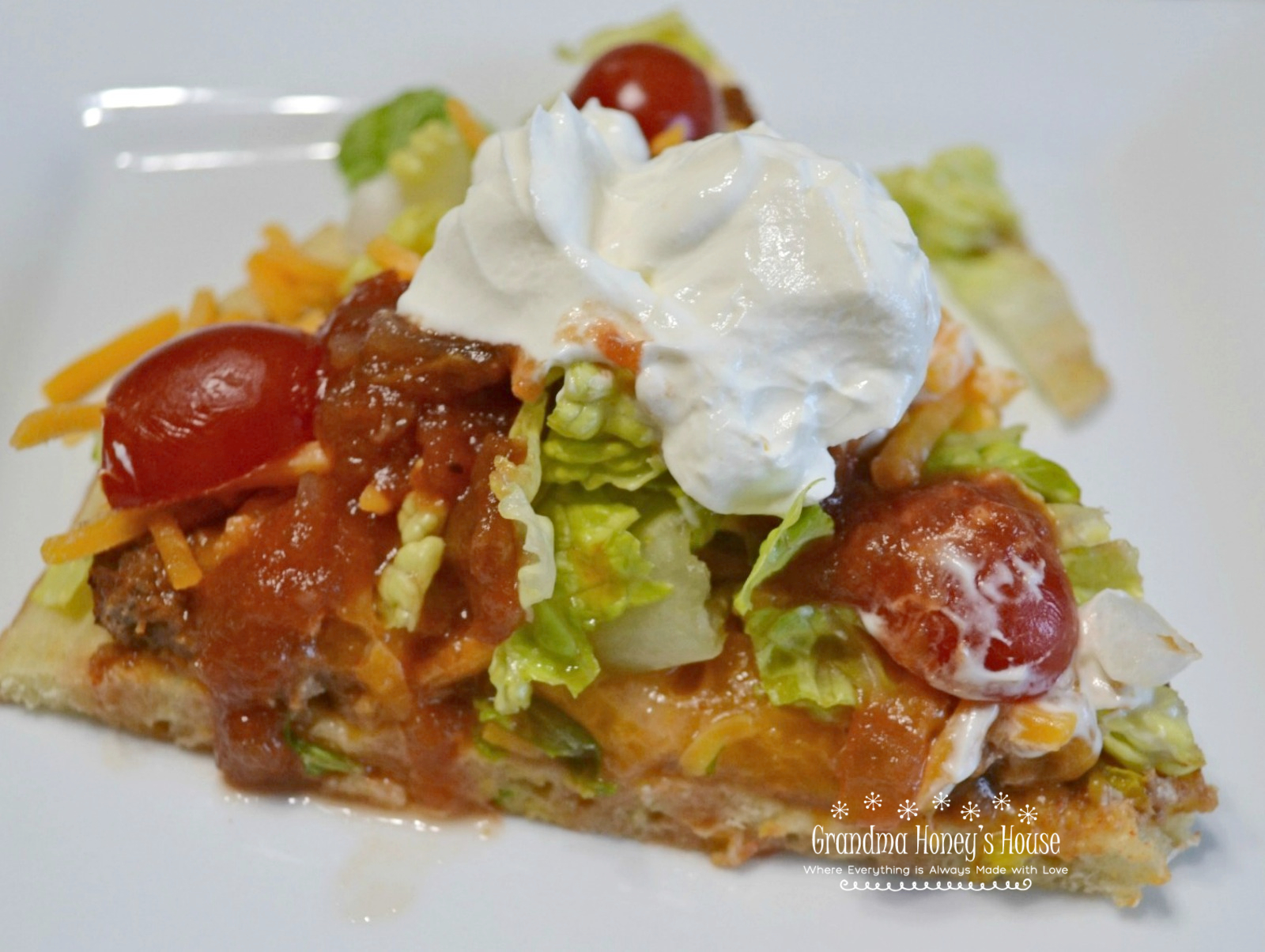 Taco Pizza Supreme is a mexican style pizza loaded with ground beef,sesoings,refried beans and cheese mixture.Taco toppings, sour cream and salsa round it off. 