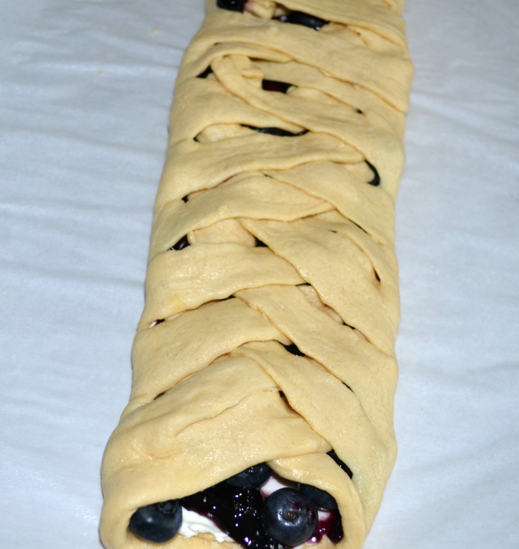 This easy breakfast braid is filled with cream cheese and blueberries then wrapped in a crescent crust. It is baked and topped with a warm, sweet glaze.