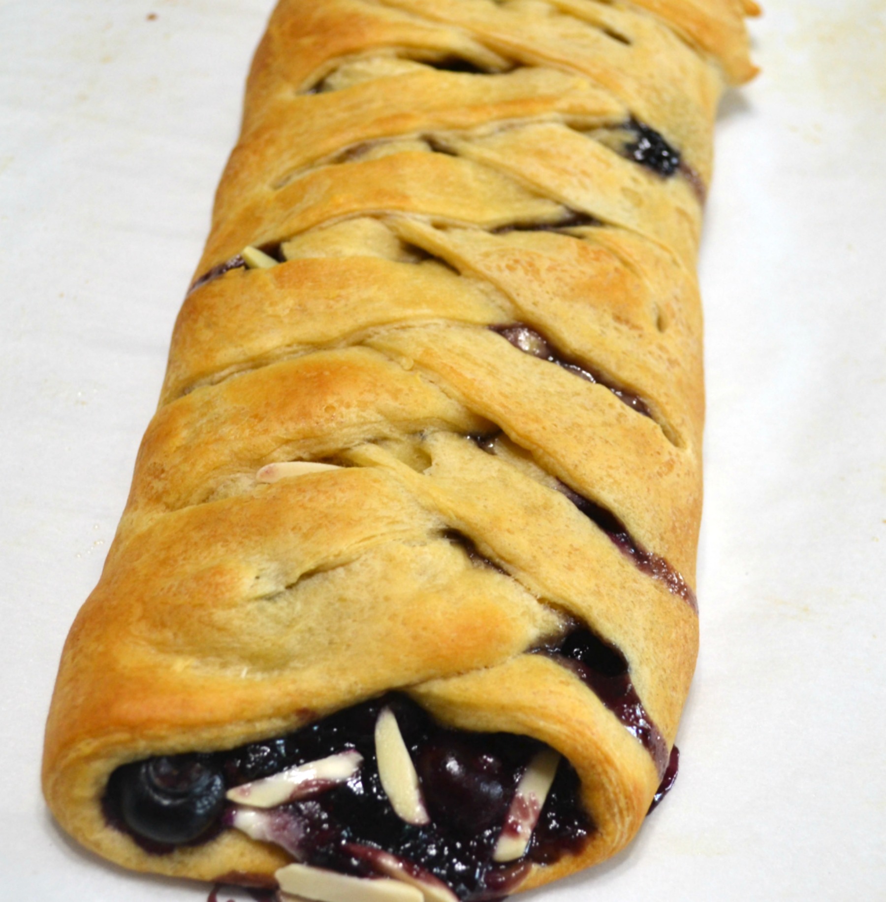 This easy breakfast braid is filled with cream cheese and blueberries then wrapped in a crescent crust. It is baked and topped with a warm, sweet glaze.