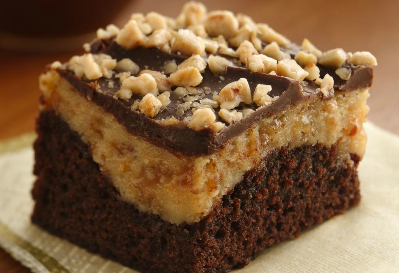 A rich dessert with a brownie based, topped with peanut butter, cream cheese, toffee bits and chocolate.