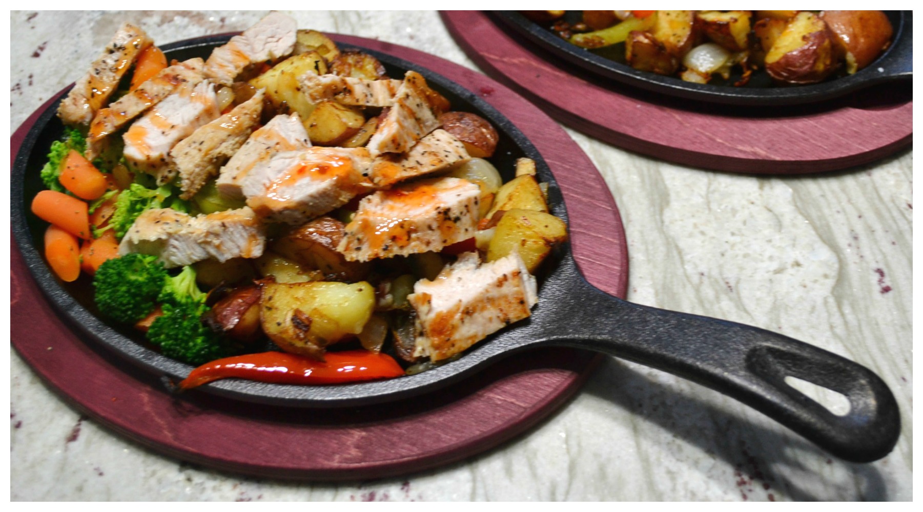 A sizzlin skillet filled with colorful veggies, sliced turkey cutlets and drizzled with sweet chili sauce.