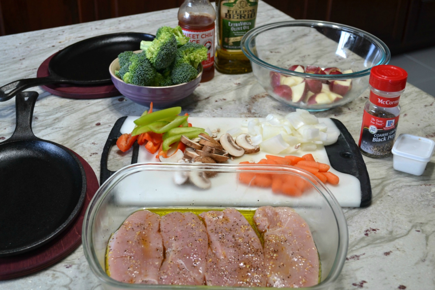 A healthy, colorful skillet dinner of fresh veggies, grilled turkey cutlets served on a cast iron skillet and drizzled with sweet chilli sauce.