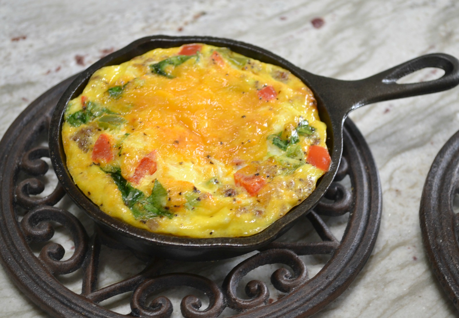 Mini Frittatas loaded with bacon ham, sausage, eggs, cheese, and veggies baked in a mini cast iron skillet.