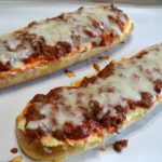 Loaves of garlic bread topped with a ricotta cheese layer, a meat sauce, and lots of melted mozzarella cheese. Perfect for dinner or cut into smaller pieces as an appetizer.