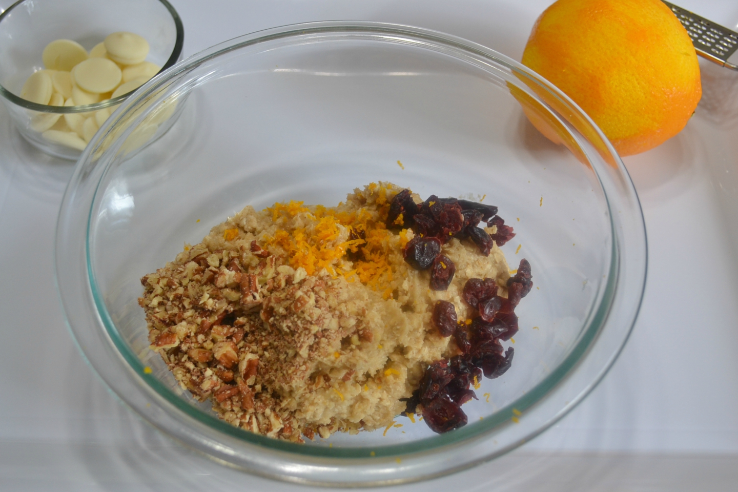 A flavorful oatmeal cookie packed with flavors from cranberry, pecans, and orange zest topped with a melted white chocolate drizzle