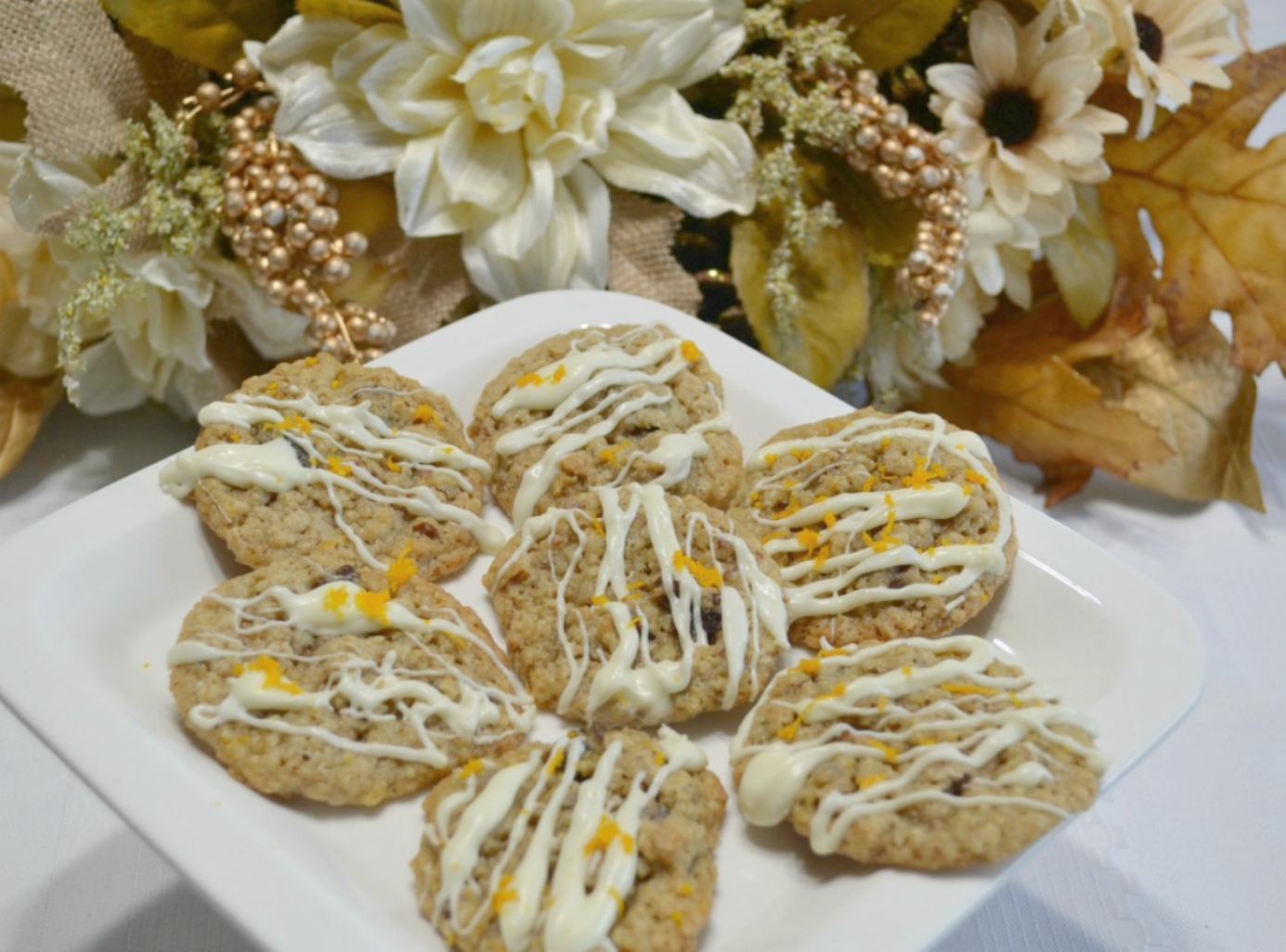 A flavorful oatmeal cookie packed with flavors from cranberry, pecans, and orange zest topped with a melted white chocolate drizzle.