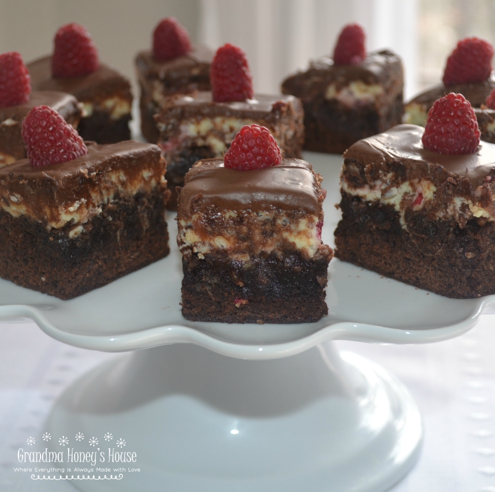 A rich, elegant brownies filled with chocolate chips, a cream cheese and raspberry filling, topped with melted chocolate. 