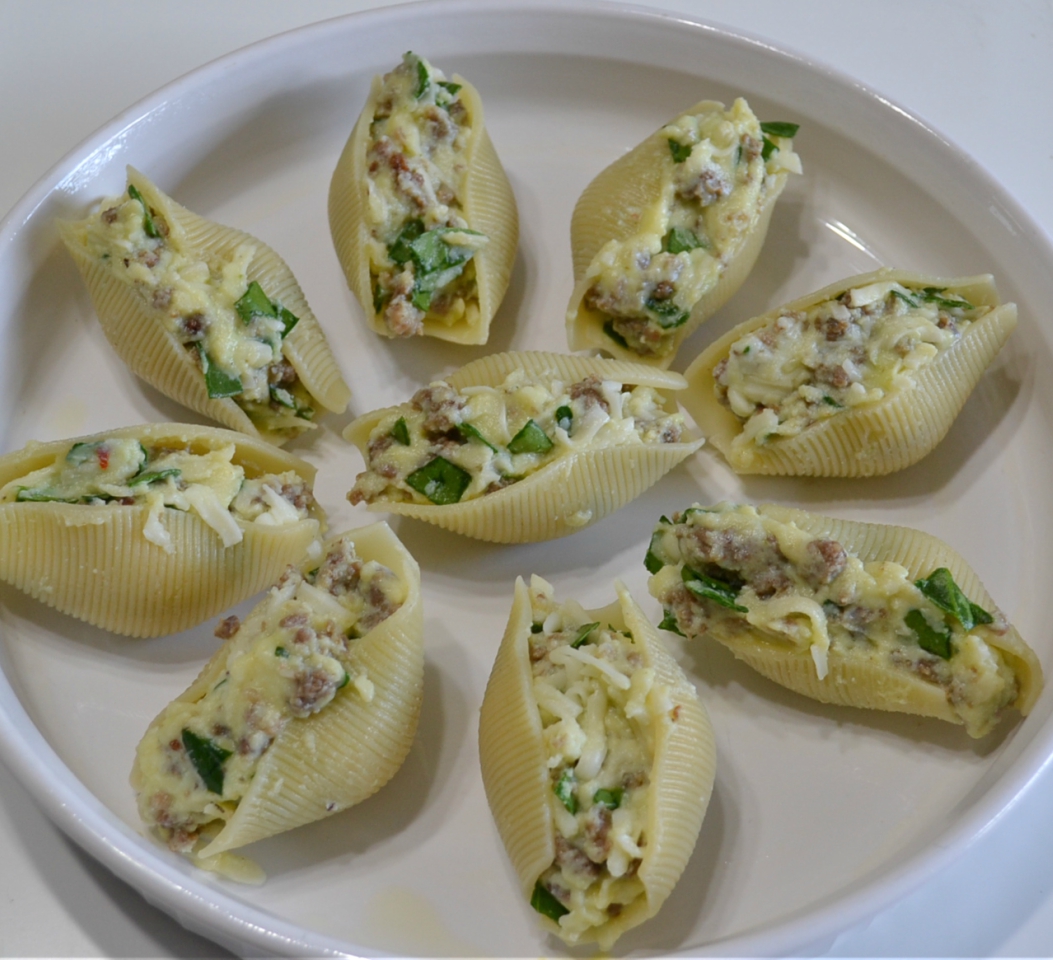 Pasta shells stuffed with a filling of spicy sausage, baby spinach, creamy ricotta and mozzarella cheese are topped with pasta sauce and more cheese. Baked to perfection and served with garlic bread for a quick dinner.