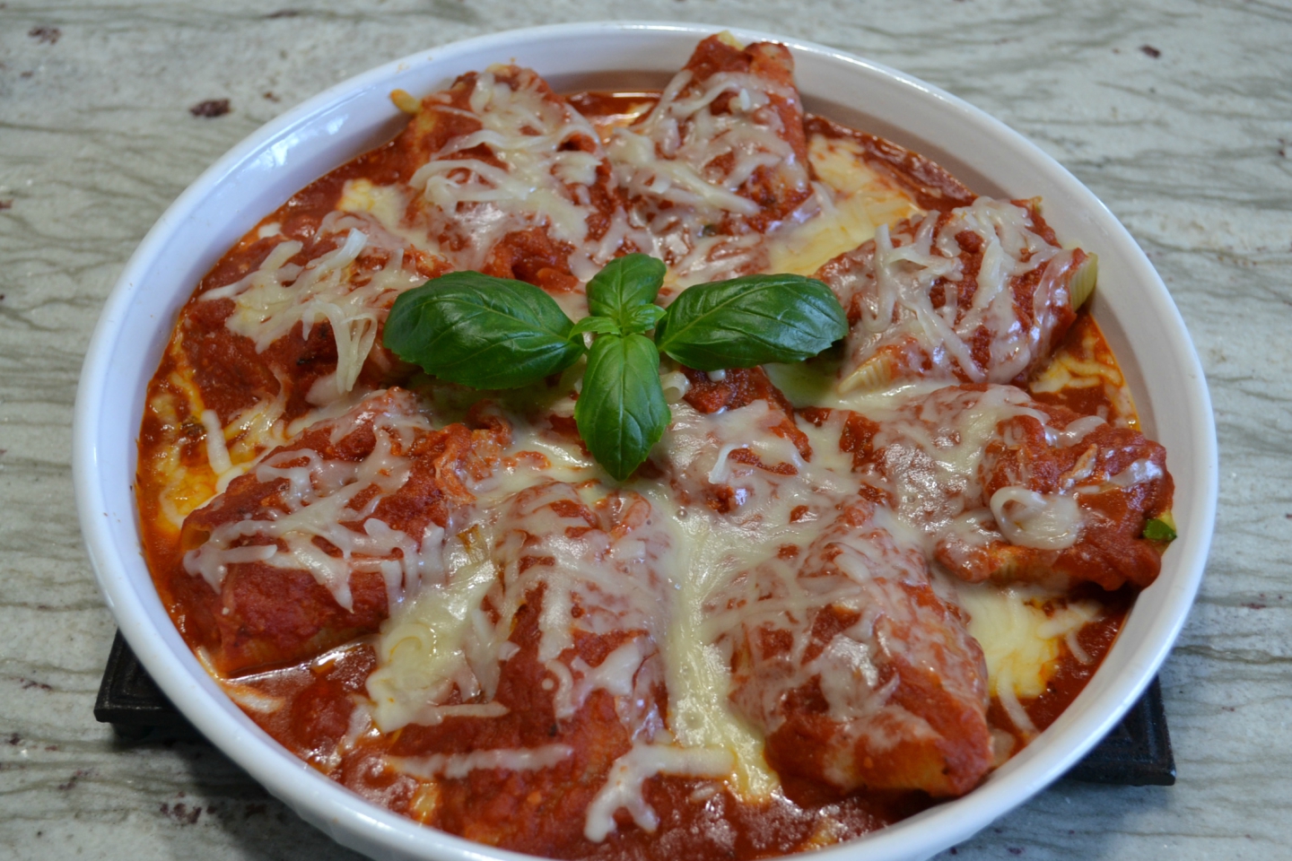 Pasta shells stuffed with a filling of spicy sausage, baby spinach, creamy ricotta and mozzarella cheese are topped with pasta sauce and more cheese. Baked to perfection and served with garlic bread for a quick dinner.