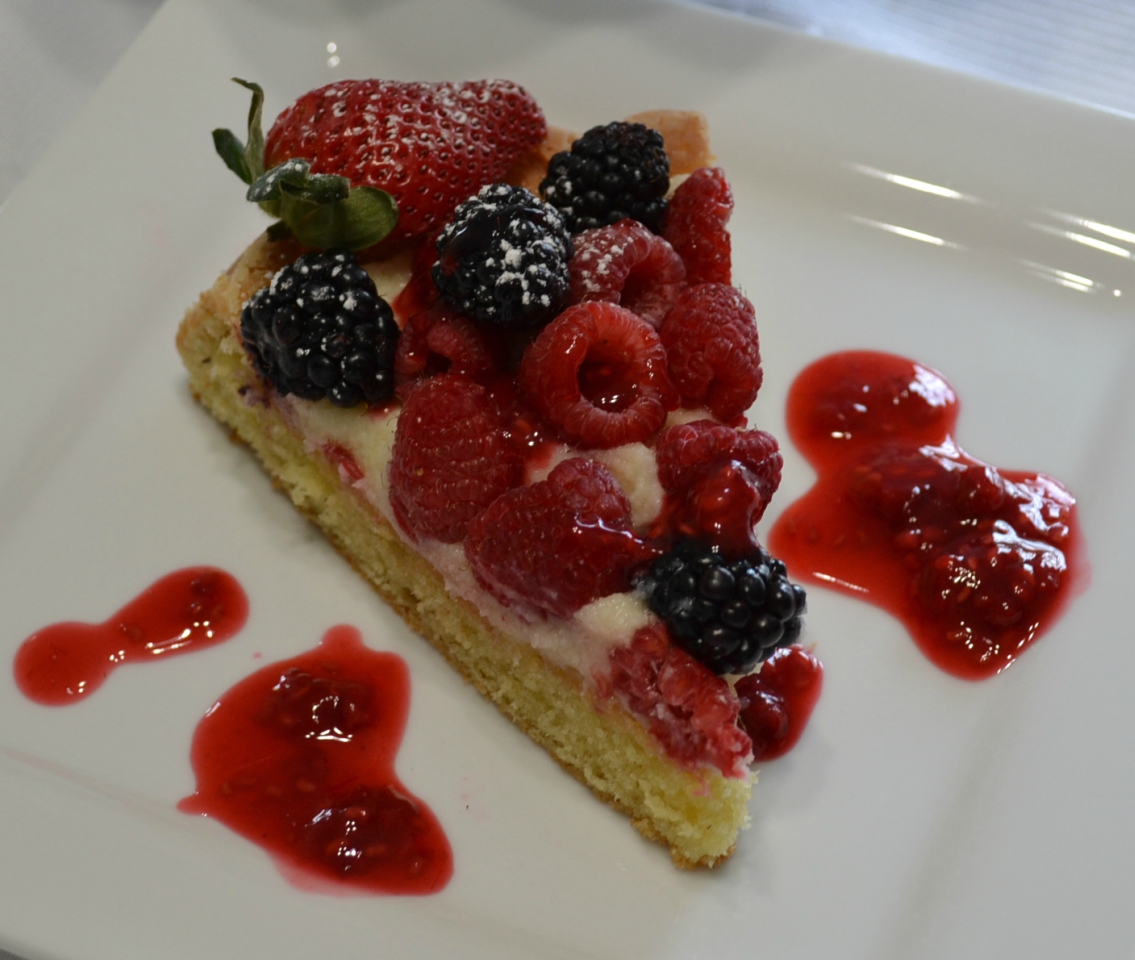 Raspberry Almond Tiara Cake is baked in a tiara pan, has almond paste in the cake, filled with a mascarpone layer and topped with fresh berries. Drizzle fresh raspberry sauce.