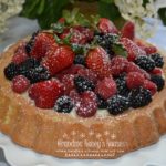 Raspberry Almond Tiara Cake is baked in a tiara pan, has almond paste in the cake, filled with a mascarpone layer and topped with fresh berries. Drizzle fresh raspberry sauce.