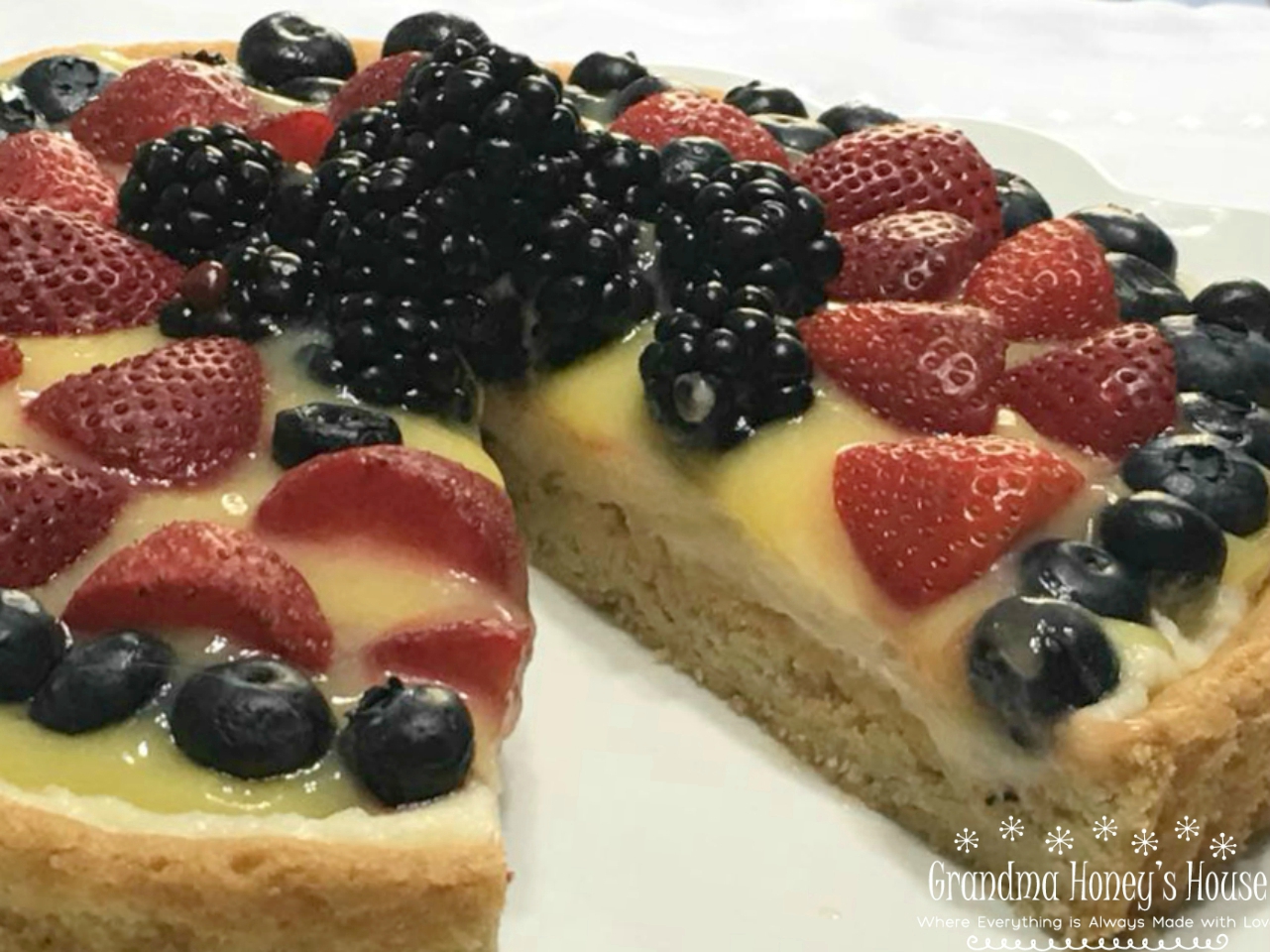 Berry Lemon Mascarpone Cookie Tart is made with a sugar cookie crust that is filled with sweetened mascarpone cheese, lemon curd, and topped with fresh berries. 