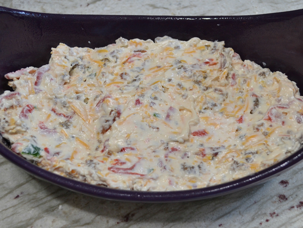 This Hot Pimento-Sausage Dip is perfect for any party. This dip has a pimento cheese base, with bacon, jalapenos, and sausage added. Perfect with chips, crackers,bread, or veggies.