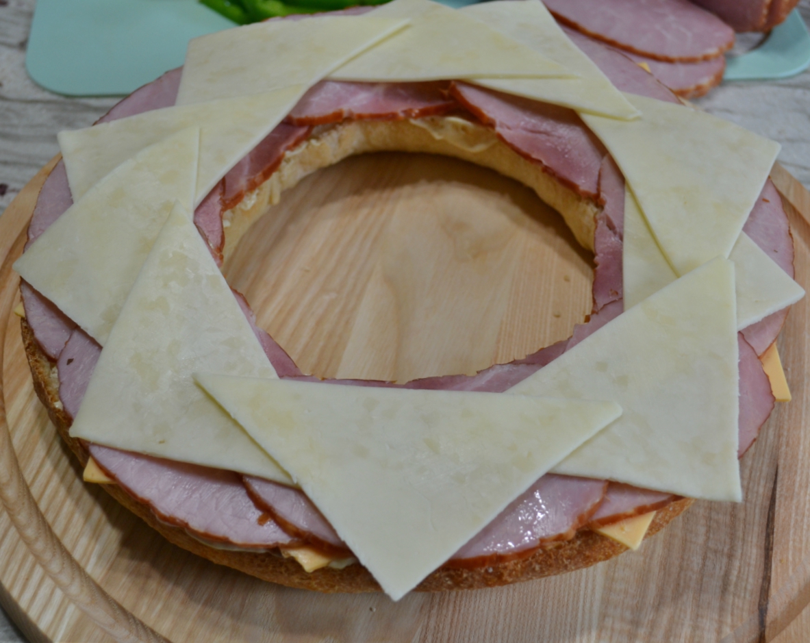 Gourmet Ham and Cheese Party Ring is perfect for any get together. A giant sandwich loaf filled with ham, cheeses, and veggies.