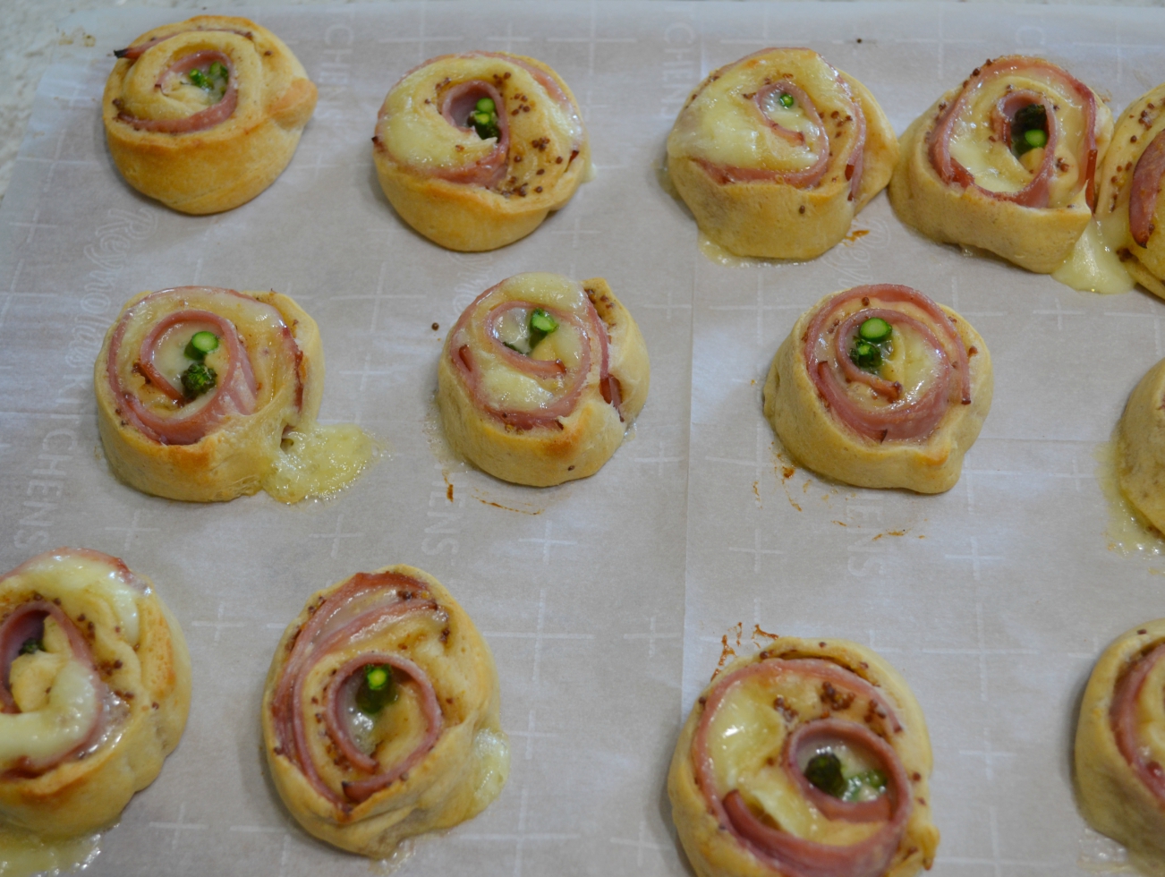 Ham-Brie-Asparagus Pinwheels are an easy appetizer with these ingredients baked in a crescent dough. They have a spread of honey mustard and warm, melted cheese.