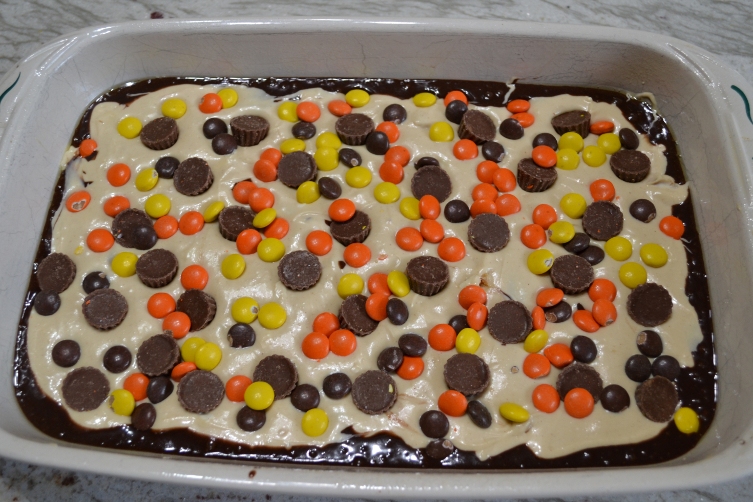 Extreme Peanut Butter Cream Cheese Brownies are extreme because they are a decadent brownie dessert, loaded with a peanut butter cream cheese layer, and then topped with a bag of Reese’s Baking Cups and Reese’s Pieces Candies