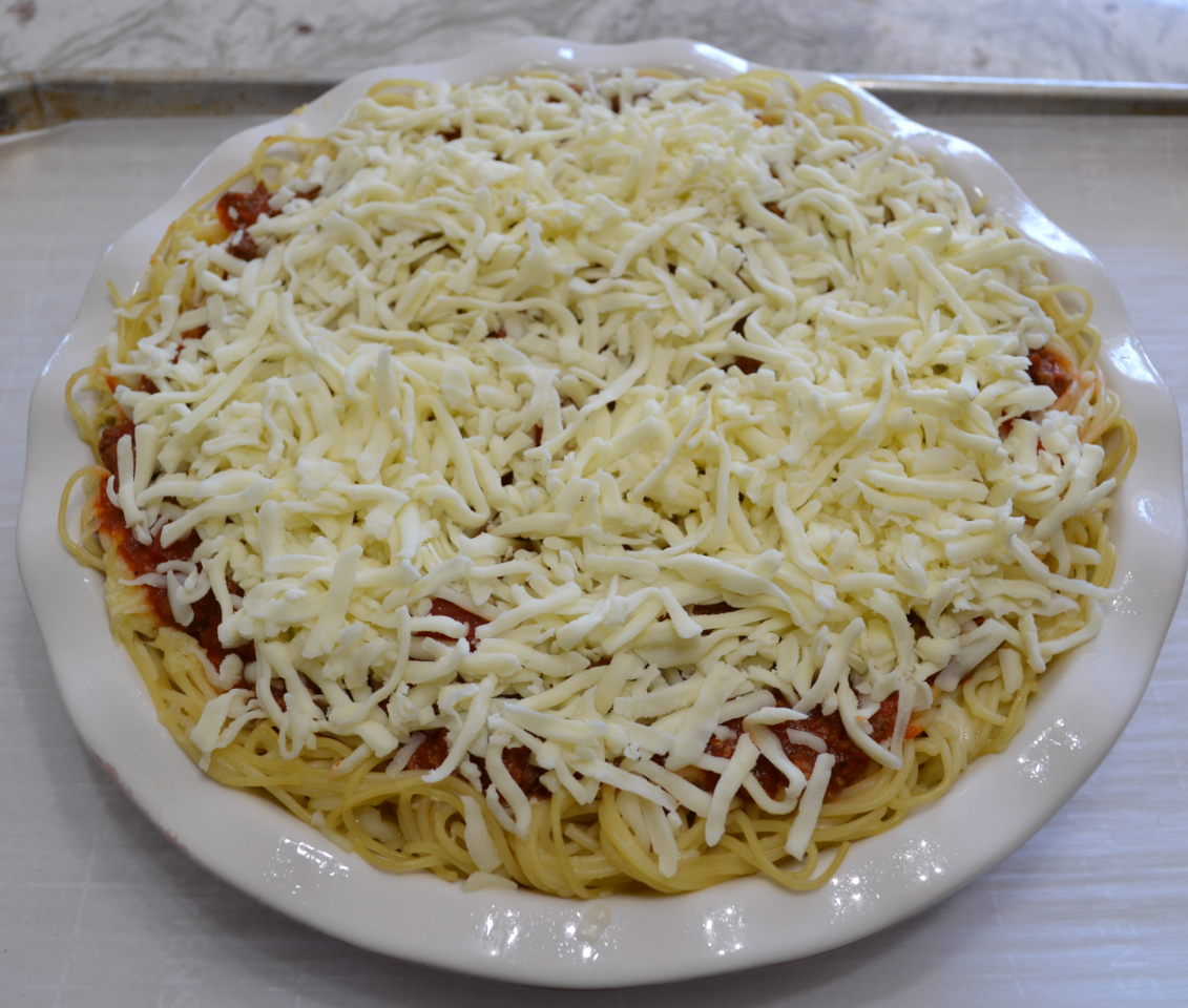 Cheesy Spaghetti Pie is baked in a deep dish pie plate with a crust of spaghetti,a layer of ricotta,then topped with homemade pasta sauce and mozzarella cheese.