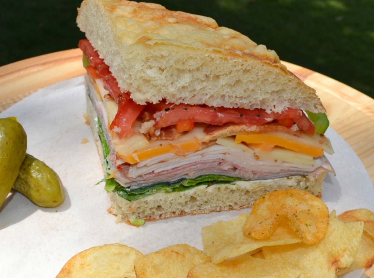 Picnic Foccacia Sandwich is loaded with meats, cheeses,and veggies. Made on a foccia loaf, drizzled with italian dressing and cut into beautiful wedges. 