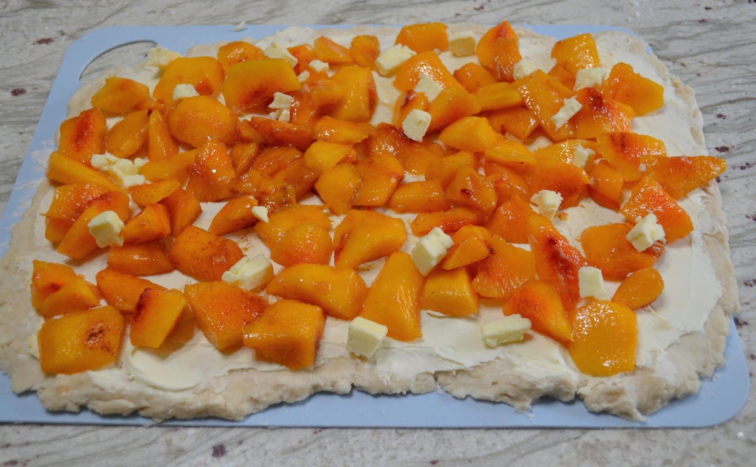 A delicious dessert made with fresh peaches and mascarpone cheese, rolled up in a shortbread crust. Baked in a simple syrup then drizzled with a mascarpone glaze.