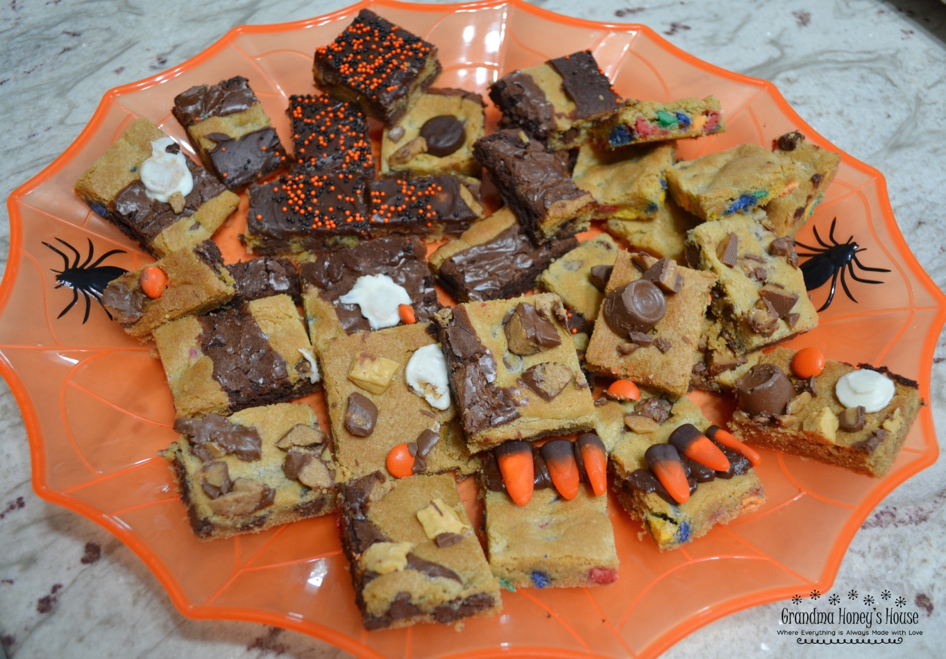 This Halloween Candy Bar Cookie is a mixture of different cookie dough, and brownie mix baked together on a sheet pan. Different candies and chips are added to dough or top the treat. 