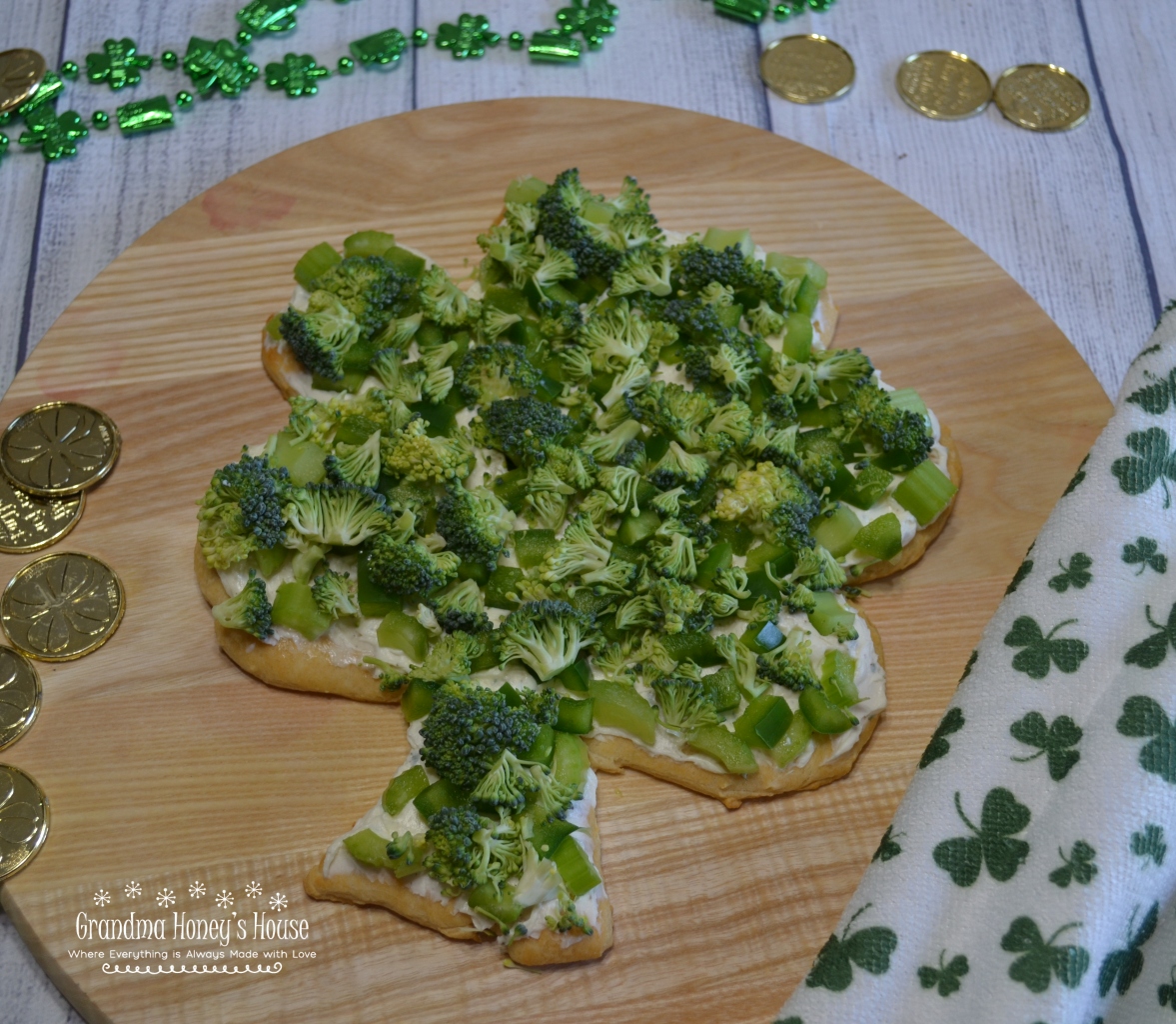 Shamrock Veggie Pizza is an easy appetizer made on a crescent dough crust, cream cheese and ranch filling, topped with green veggies for St Patrick's Day.