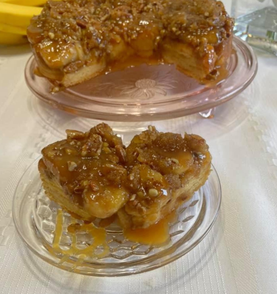 A panful of sticky, pull-apart rolls made with refrigerated biscuits, bananas, butter, brown sugar, nuts, and  drizzled with caramel topping.