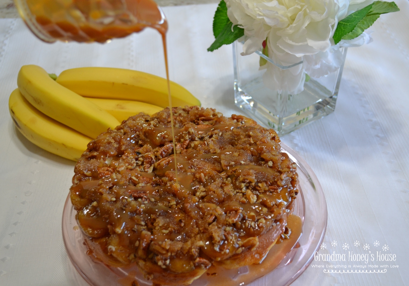 A panful of sticky, pull-apart rolls made with refrigerated biscuits, bananas, butter, brown sugar, nuts, and  drizzled with caramel topping.