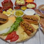 This cookout board for 2 includes burgers, hot dogs and all of the sides served at any summer get together.