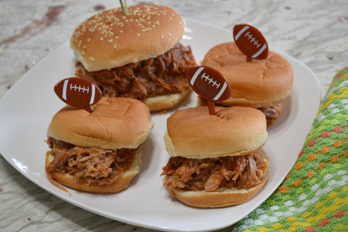 These Pulled Pork Sliders are perfect for any get together. Pork butt rubbed with a homemade rub, cooked in a crockpot, and covered with a homemade BBQ sauce.