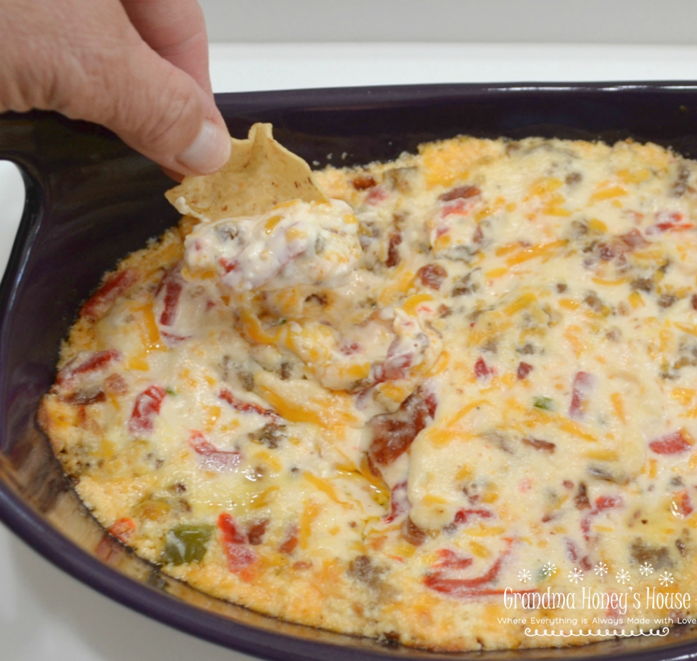 This Hot Pimento-Sausage Dip is perfect for any party. This dip has a pimento cheese base, with bacon, jalapenos, and sausage added. Perfect with chips, crackers,bread, or veggies.