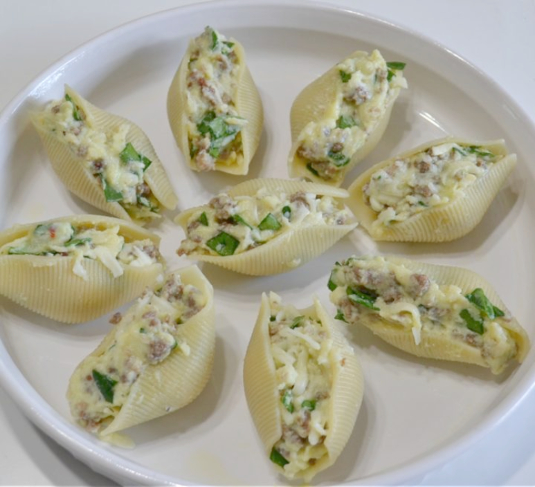 Pasta shells stuffed with a filling of spicy sausage, baby spinach, creamy ricotta and mozzarella cheese are topped with pasta sauce and more cheese. Baked to perfection and served with garlic bread for a quick dinner.
