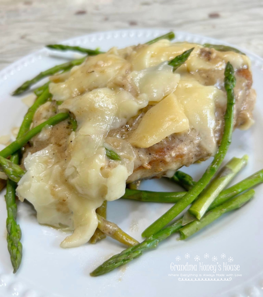 Cheesy Chicken Asparagus Dinner..pan fried chicken breasts, fresh asparagus, simmered in a white wine sauce and smothered with melted Italian cheeses.