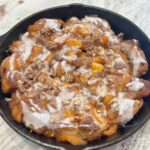 Cinnamon Roll Peach Cobbler Skillet.... a mixture of fresh peaches, cinnamon, sugar and vanilla, poured over a crust of refrigerated cinnamon rolls in a cast iron skillet and baked