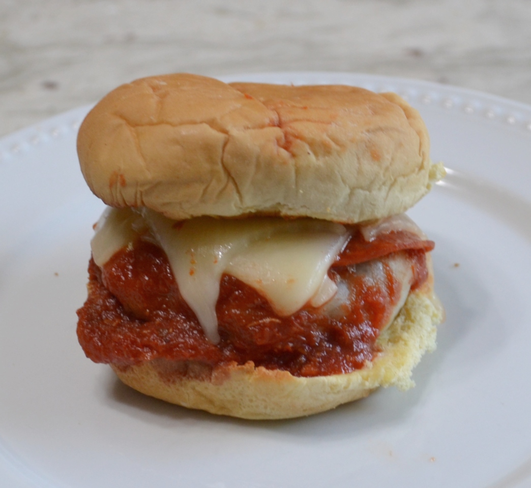 Pizza Burgers are seasoned ground beef patties, layered with mozzarella cheese, pepperoni, veggies, and topped with spoonfuls of warm pizza sauce. Serve on a garlic butter toasted bun.