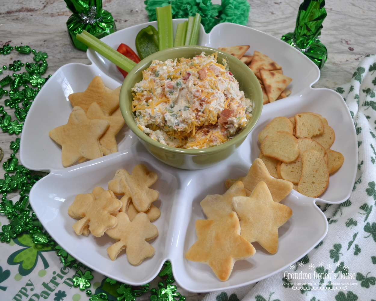 Vegetable Pizza Dip with bacon is a creamy dip made with cream cheese, sour cream, mayo, a Ranch dressing packet, a mixture of veggies, cheese and bacon.  It is served cold with a variety  of breads, crackers, chips, and celery sticks