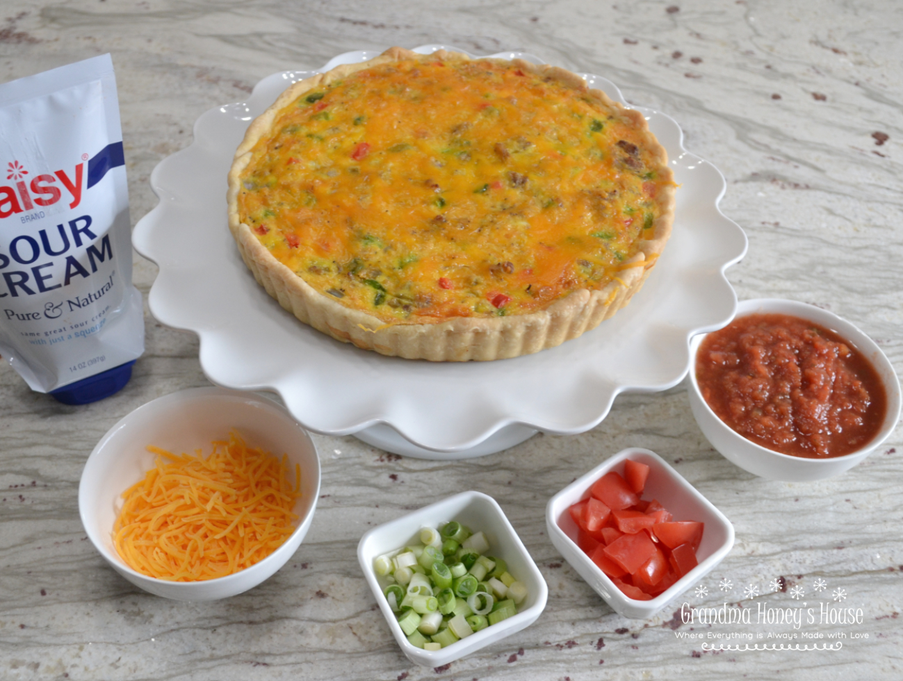 Southwest Breakfast Tart is packed with sausage, peppers, green chiles, cheese, eggs, and baked in a pie crust. It is served with toppings of salsa, sour cream, green onions and diced tomatoes.  