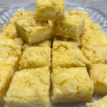 Easy cheesecake bars using a cake mix as a base, cream cheese and Lemon filling, topped with a crumble of the cake mix mixture.
