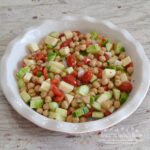 Cucumber and Chickpea Salad is a colorful and easy to make summer salad or side dish made with chickpeas, cucumbers, tomatoes, peppers, onions and provolone cheese. It is drizzled with a tangy dressing and chilled. 