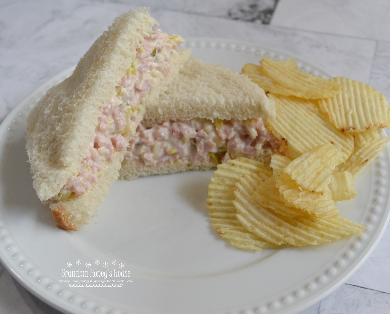 These ham salad sandwiches are made with cooked ham, dijon mustard, mayonnaise, swiss cheese, and sweet relish